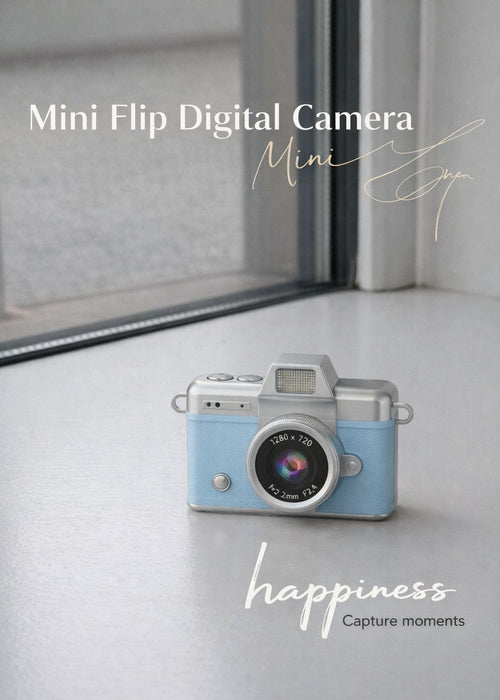 Vintage style blue mini flip digital camera held in hand